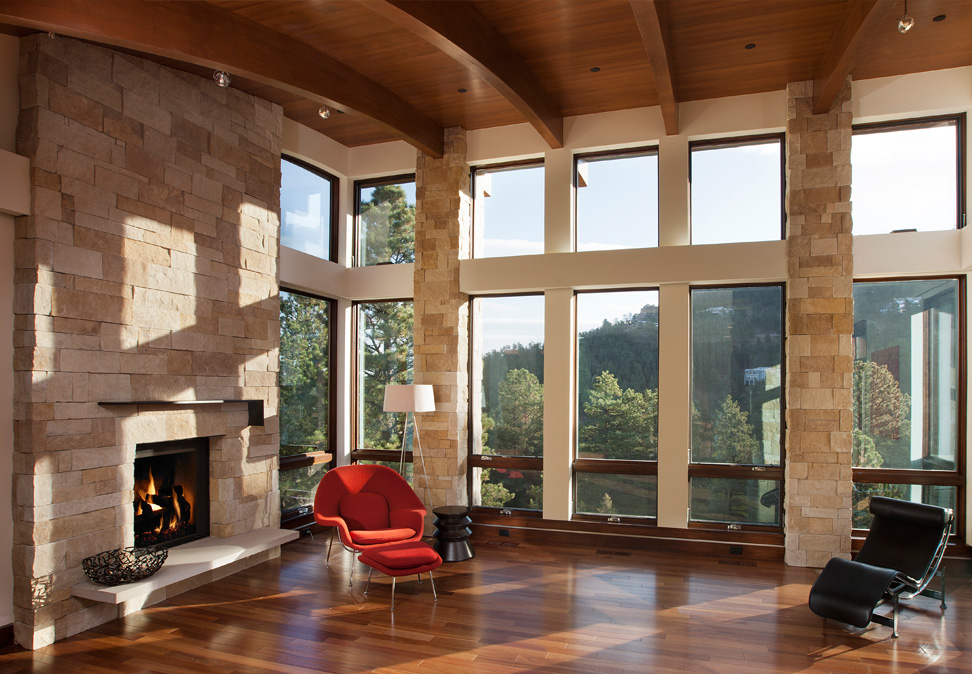 Custom green home livingroom with floor to ceiling windows and Brazilian redwood flooring