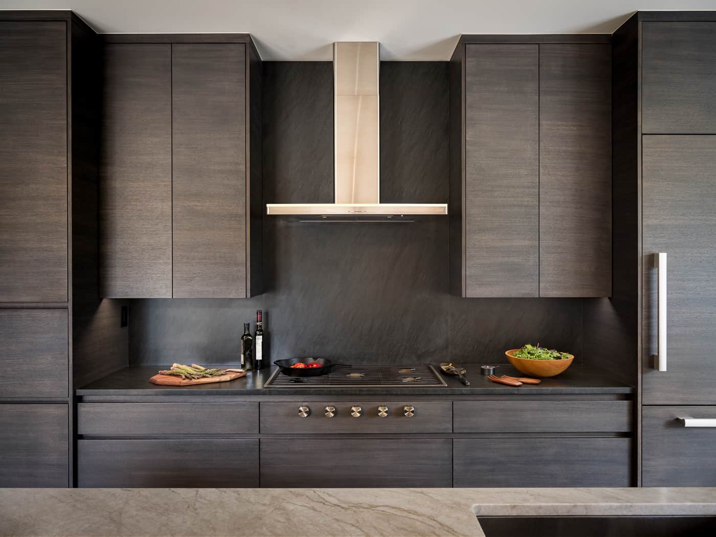 Custom modern kitchen with dark cabinets and stone topped island