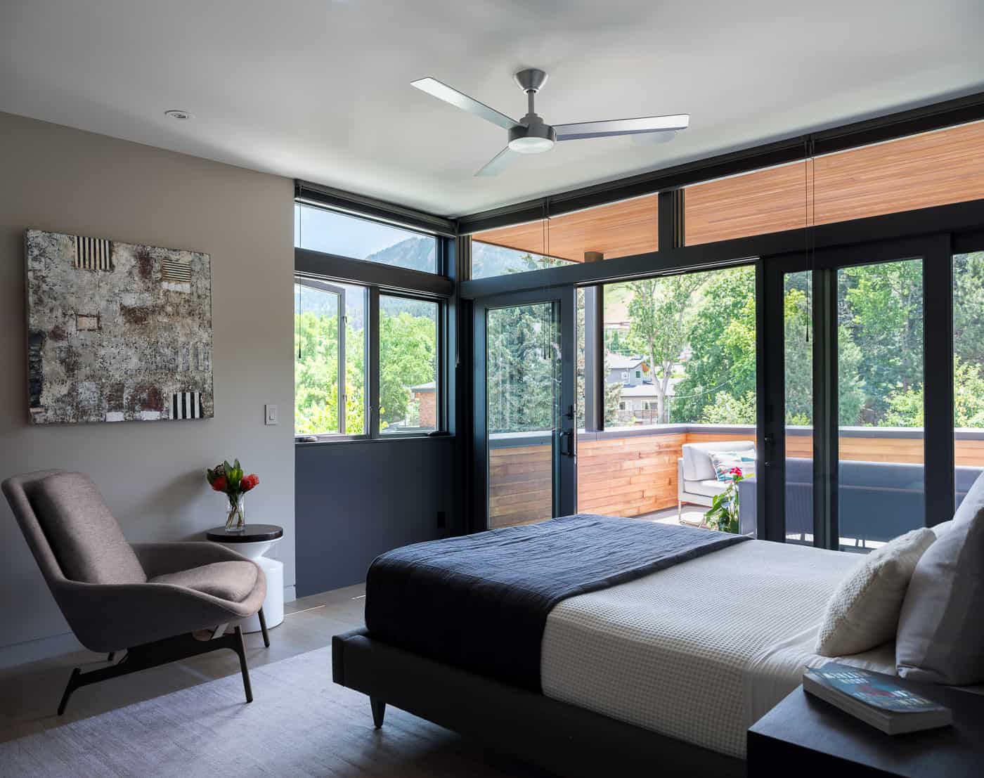 Modern bedroom with floor to ceiling windows and patio