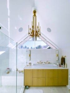 Modern master bathroom with white walls and brass accents and quartz counter tops