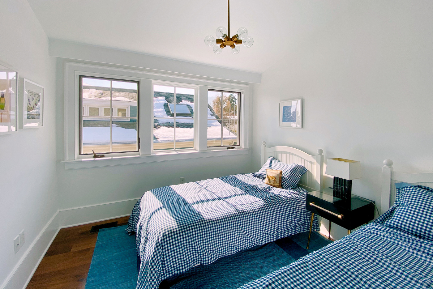Remodeled kids bedroom with two twin beds and large windows