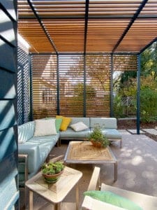 Sunny patio covered by minimalist steel and wood trellis